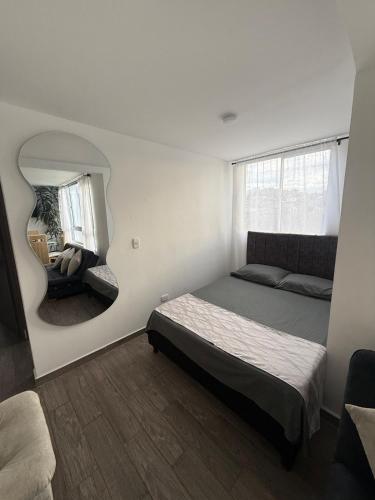 a bedroom with a bed and a mirror at Simplemente en Casa! in Manizales