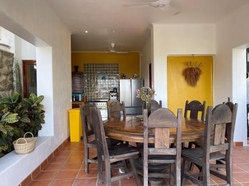 a kitchen and dining room with a wooden table and chairs at Villa Las Palmas San Pancho in San Francisco