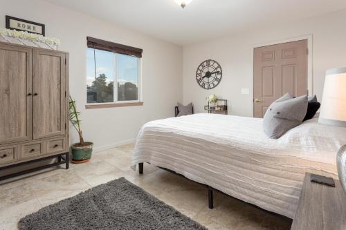 a bedroom with a large bed and a clock on the wall at Serendipity Retreat - Dogs Welcome Farm Tours and Private Yoga Sessions in Atascadero