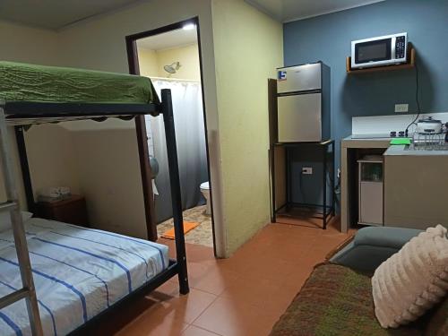 a small room with a bunk bed and a kitchen at Granja Agua Azul, Wi-FI,AC-WC,Parking,la Fortuna in Fortuna