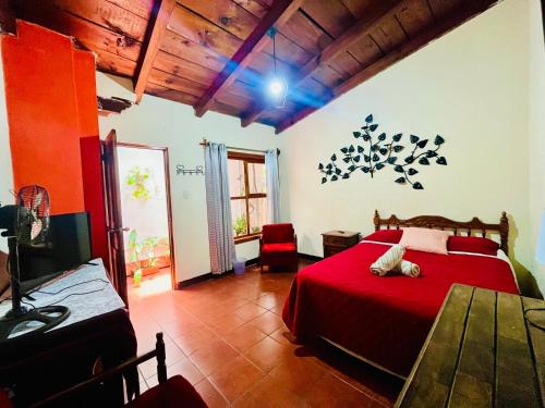 a bedroom with a red bed with a red blanket at La casita de Charlie in Antigua Guatemala