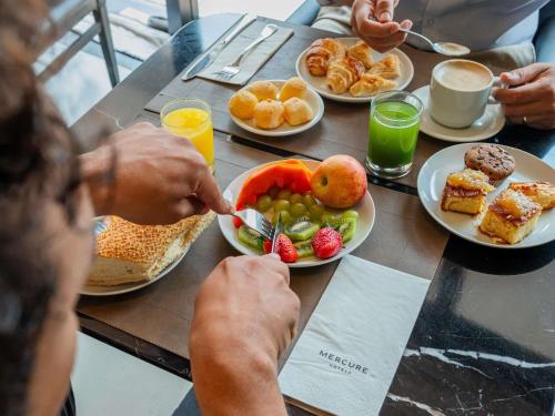 a group of people sitting at a table eating breakfast at Mercure Belem Boulevard in Belém