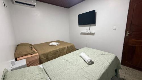 a room with two beds and a flat screen tv at Comfort & Practicality in Macapá