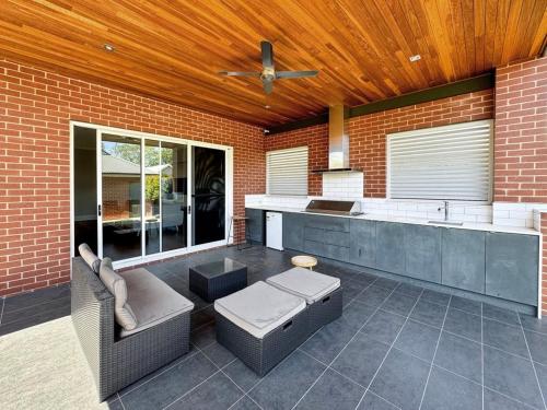 a kitchen with a couch and a ceiling fan at Peter's Central Haven in Wagga Wagga