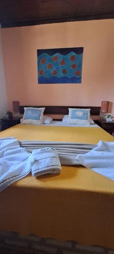 two beds with towels sitting on top of them at Fiquei In Pipa - Chalé 21 in Pipa