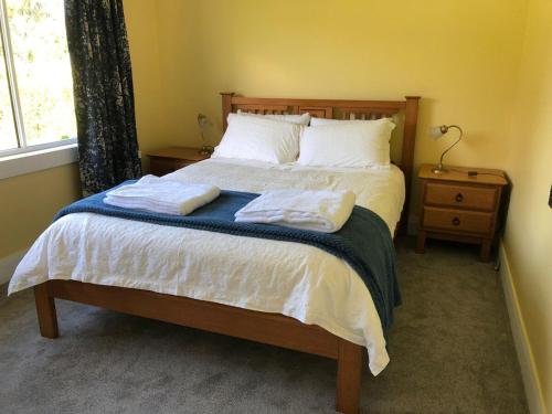 a bedroom with a bed with two towels on it at The yellow house in Lower Barrington