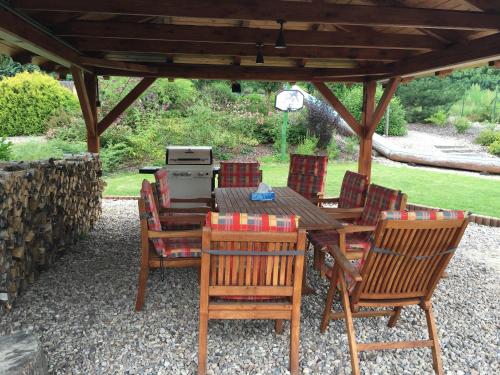 a wooden table and chairs under a pavilion at Apartmány PEMI Potštejn in Potštejn