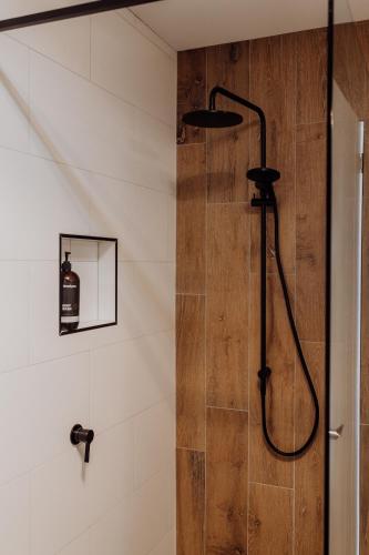 a shower in a bathroom with a wooden wall at Doric Dreams - Short Stroll to St Helens in St Helens