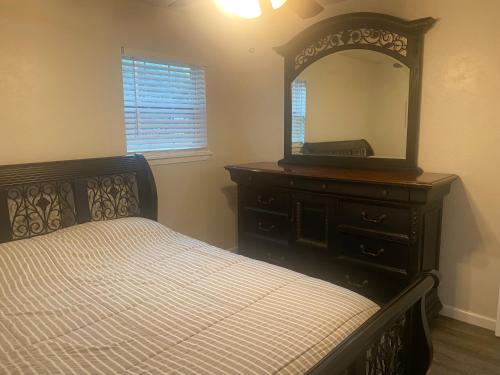 a bedroom with a bed and a dresser with a mirror at 2bd 1bth Newly Renovated Home near Cowboys Stadium etc in Arlington