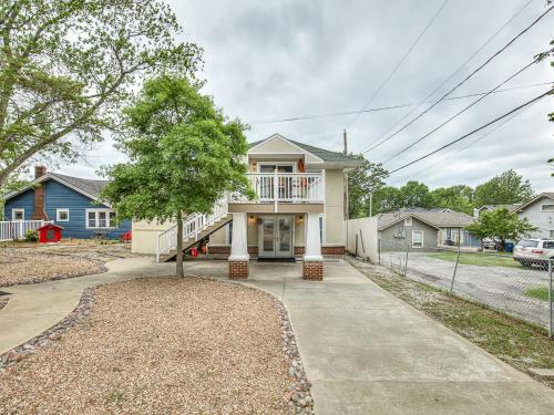 a white house with a porch and a tree at Cozy 1-Bedroom Retreat in Tulsa in Tulsa