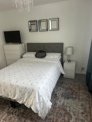 a bedroom with a bed and two night stands and a television at The Cosy Haven - 2 Bedroom house in Manchester