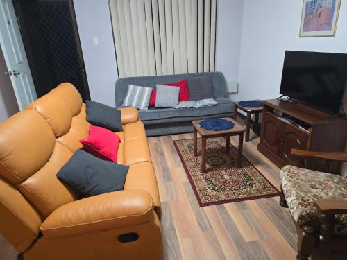 a living room with a couch and a television at Champion Bay Beach Unit, with own carport, in Geraldton