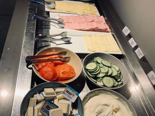 Cuatro tazones de diferentes tipos de queso y verduras. en ibis Styles Montevideo Biarritz, en Montevideo