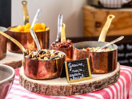 a display of food in copper pots on a table at greet Hotel Beaune in Beaune