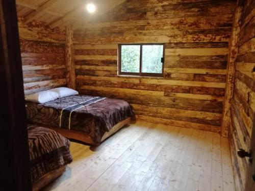 a bedroom with a bed in a log cabin at cabañas cruz verde in Pinal de Amoles