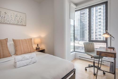a bedroom with a bed and a desk and a window at Corner 2BR Old Port - Free Indoor Parking in Montreal