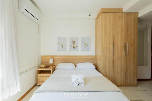 une chambre avec deux lits et une armoire en bois dans l'établissement Flat Moderno p/ Negócios em Asa Norte BHY0614, à Brasilia