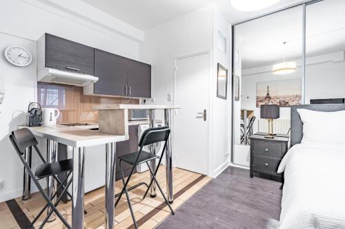 ein Schlafzimmer mit Bett und eine Küche mit Schreibtisch in der Unterkunft Chic Studio - Rivoli in Paris