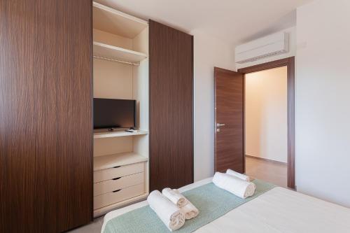 a bedroom with a bed and a television and towels at Residence Black Line - Affitti Brevi Italia in Foggia