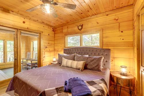 Un dormitorio con una cama en una cabaña de troncos en Blue Ridge Cabin with Hot Tub, Fire Pit, and Game Room, en Cherry Log