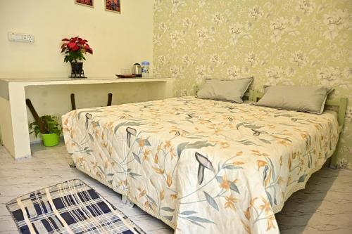 a bedroom with a bed and a table with flowers at Prakriti wellness stay in Haridwār