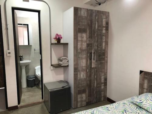 a bathroom with a mirror and a toilet and a sink at La Curva Apartamentos in Cali