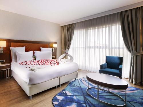 a hotel room with a bed and a blue chair at Mercure Istanbul Bakirkoy in Istanbul