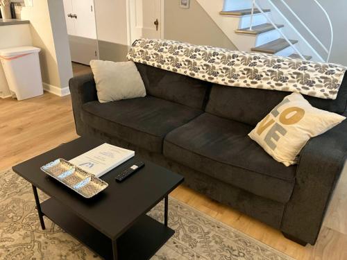 a black couch with a table in a living room at Davenport Dwellings Midtown Convenience in Omaha