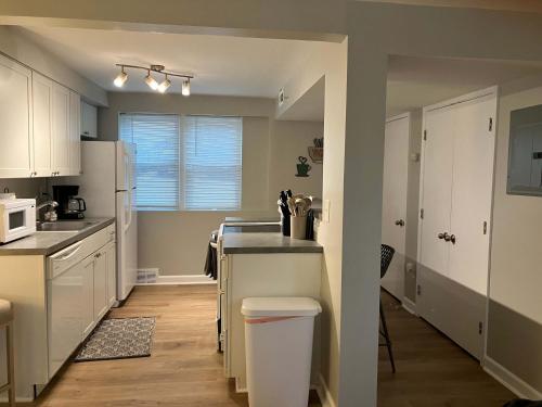 a kitchen with white cabinets and a white refrigerator at Davenport Dwellings Midtown Convenience in Omaha