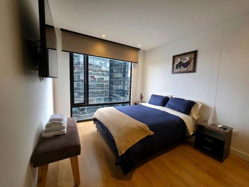 a bedroom with a large bed and a large window at AH/Luxe penthouse con balcón,Wifi+Parking; Usaquén in Bogotá
