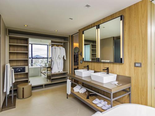 a bathroom with two sinks and a large mirror at Mercure Itajai Navegantes in Itajaí
