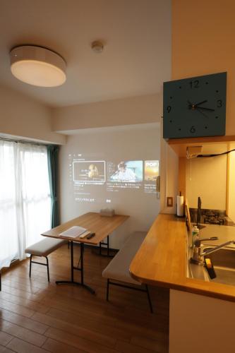 a room with a table and a clock on the wall at SN4C 和洋くつろぎの空間 大須 鶴舞駅最寄り 栄まで徒歩圏内 最大6名 Japanese and Western Relaxing Space Closest to Osu Tsurumai Station Within walking distance to Sakae Maximum 6 people in Nagoya