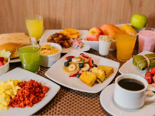 a table with plates of breakfast foods and drinks at ibis Trujillo in Trujillo
