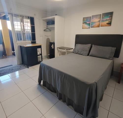 une chambre avec un grand lit dans une pièce dans l'établissement Montego Bay Garden Studio, à Montego Bay