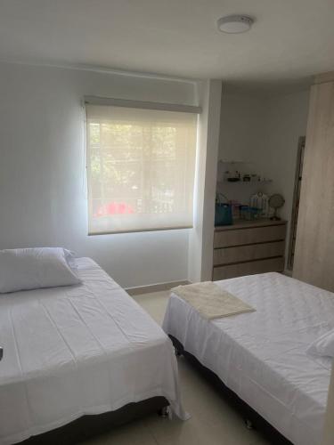 a bedroom with two beds and a window with a window blind at Full apartment near El Poblado in Medellín