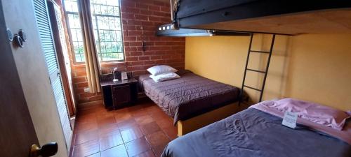 a room with two beds and a bunk bed at Casa de Campo Bheta in Guatapé