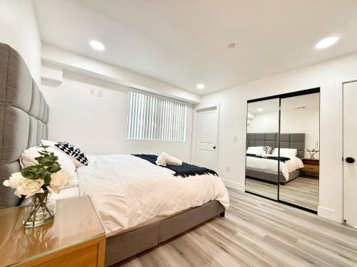 1 dormitorio con 1 cama grande y un jarrón de flores en GilmoreOne, en Van Nuys