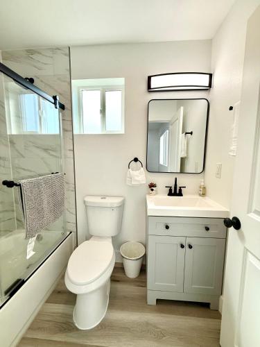 ein Badezimmer mit Toilette, Waschbecken und Spiegel in der Unterkunft GilmoreOne in Van Nuys