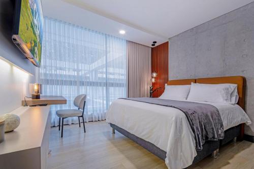 a bedroom with a bed and a desk and a chair at R211 Loft with large balcony, infinity pool and spa in Estación El Salto