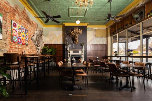 a restaurant with tables and chairs and a fireplace at The Mile End Hotel in Adelaide
