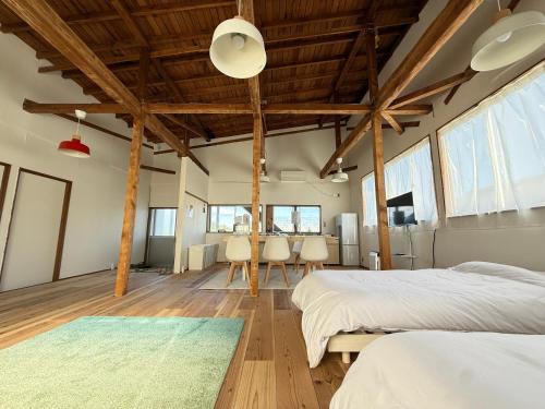 a bedroom with two beds and a table with chairs at 大型犬もOK!!天井高く広々空間の完全プライベート一軒家 Fully private house with high ceilings and a spacious layout even large dogs are welcome! in Yonezawa