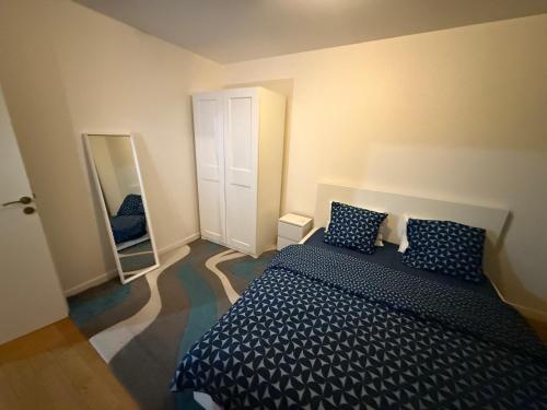 a bedroom with a large bed and a mirror at Appartement à 15 mins de Paris in Châtillon