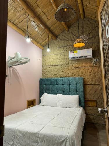 a bedroom with a bed with a green head board at Hotel Alikaa Guajira in Ríohacha