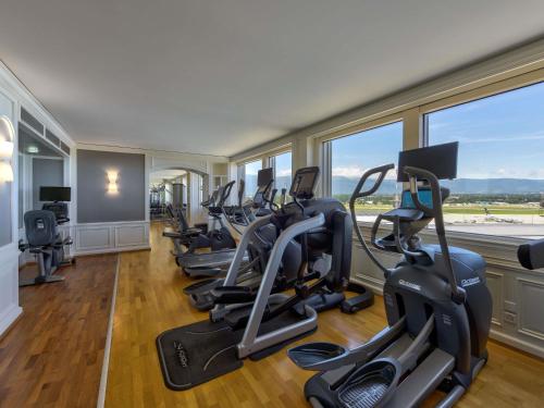 a row of treadmills in a gym with a row of treadms at Mövenpick Hotel Geneva in Geneva