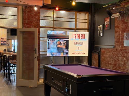 a pool table in a room with a tv at The Mile End Hotel in Adelaide