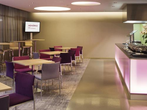 Un comedor con mesas y sillas moradas. en Mövenpick Hotel Zürich-Regensdorf, en Regensdorf