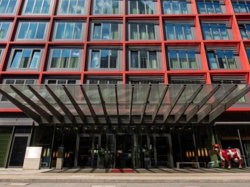 a large red building with a metal roof at Mövenpick Hotel Frankfurt City Messe in Frankfurt/Main