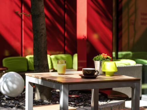 une table avec un verre de jus d'orange et une tasse de café dans l'établissement Mövenpick Hotel Frankfurt City Messe, à Francfort-sur-le-Main