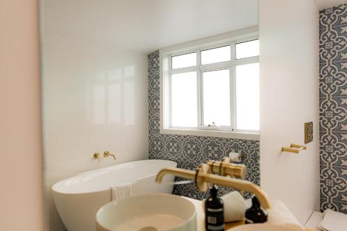 a bathroom with a tub and a sink at Bicheno Beach House in Bicheno