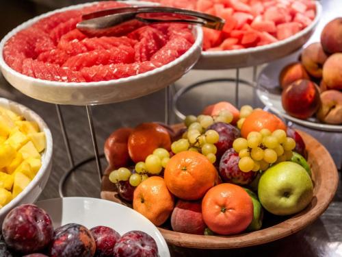 um monte de tigelas de fruta numa mesa em Mövenpick Hotel München-Airport em Hallbergmoos